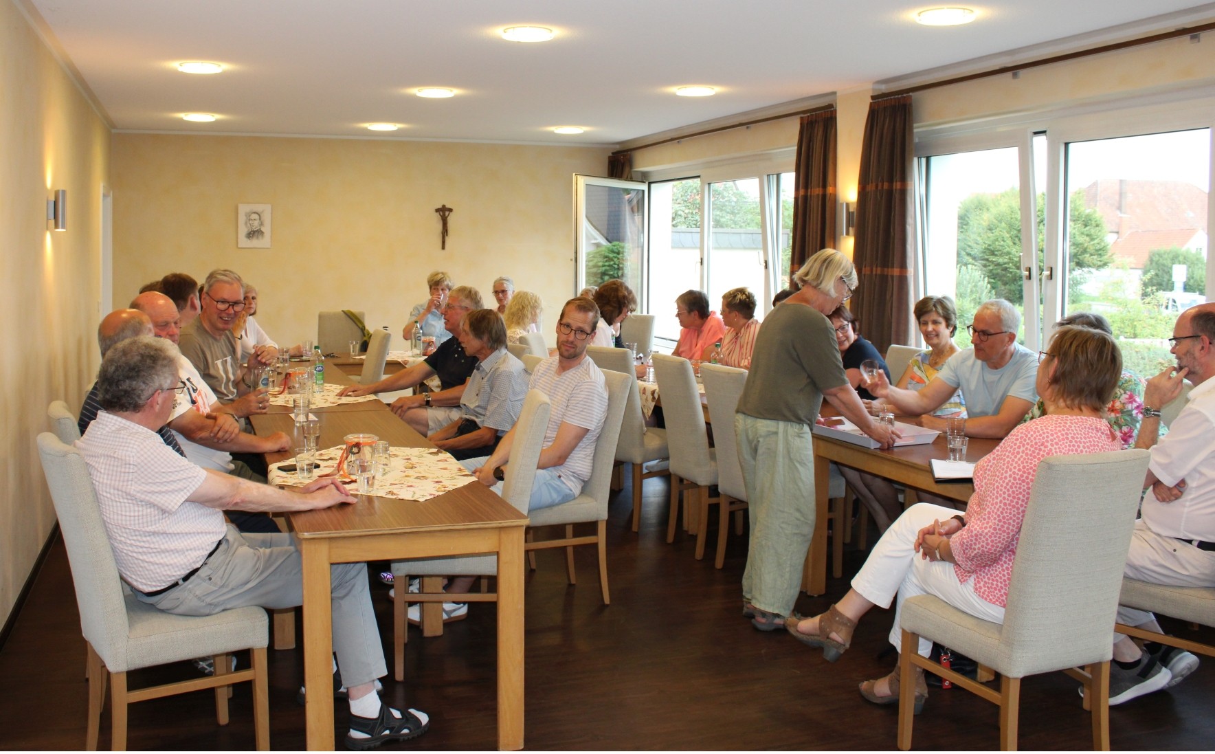 Viele Menschen sitzen in einem Raum an Tischen